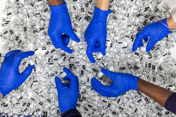 pile of vaccines with gloved hands