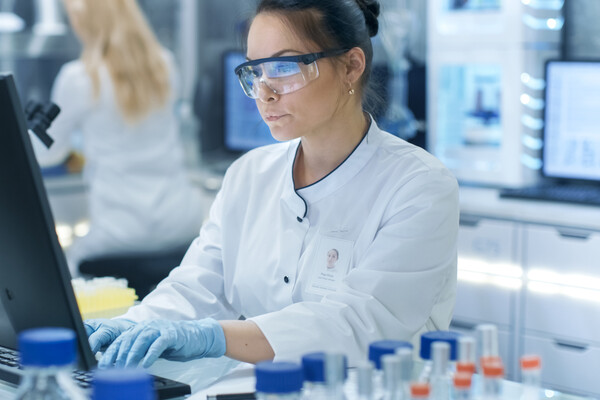 Female researcher working on a computer in a lab.