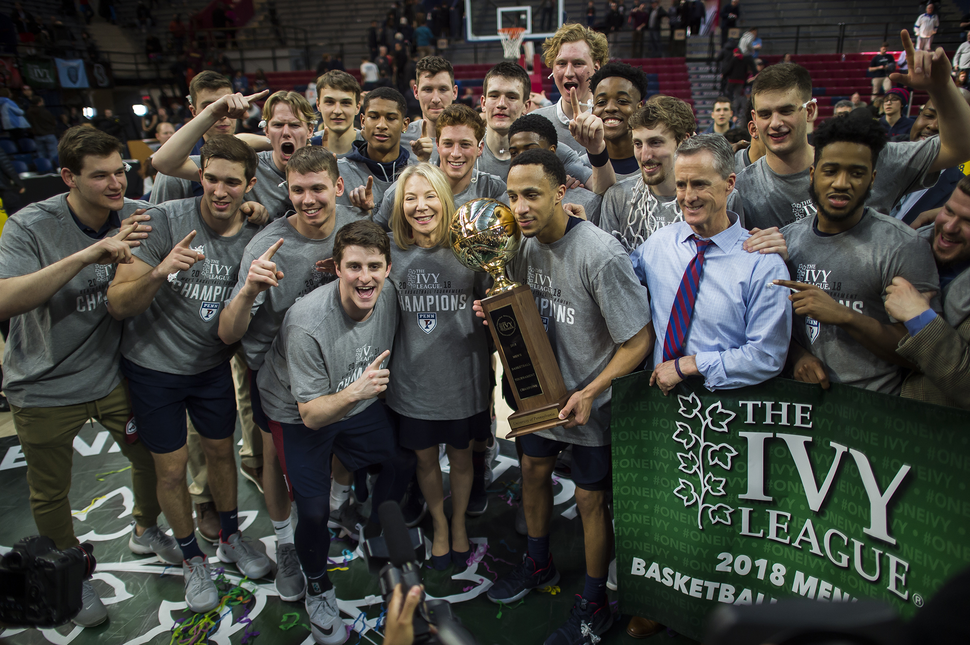 Penn President Amy Gutmann celebrates with the men’s basketball team after their victory over Harvard in the Ivy League Tournament championship game on Sunday, March 11.