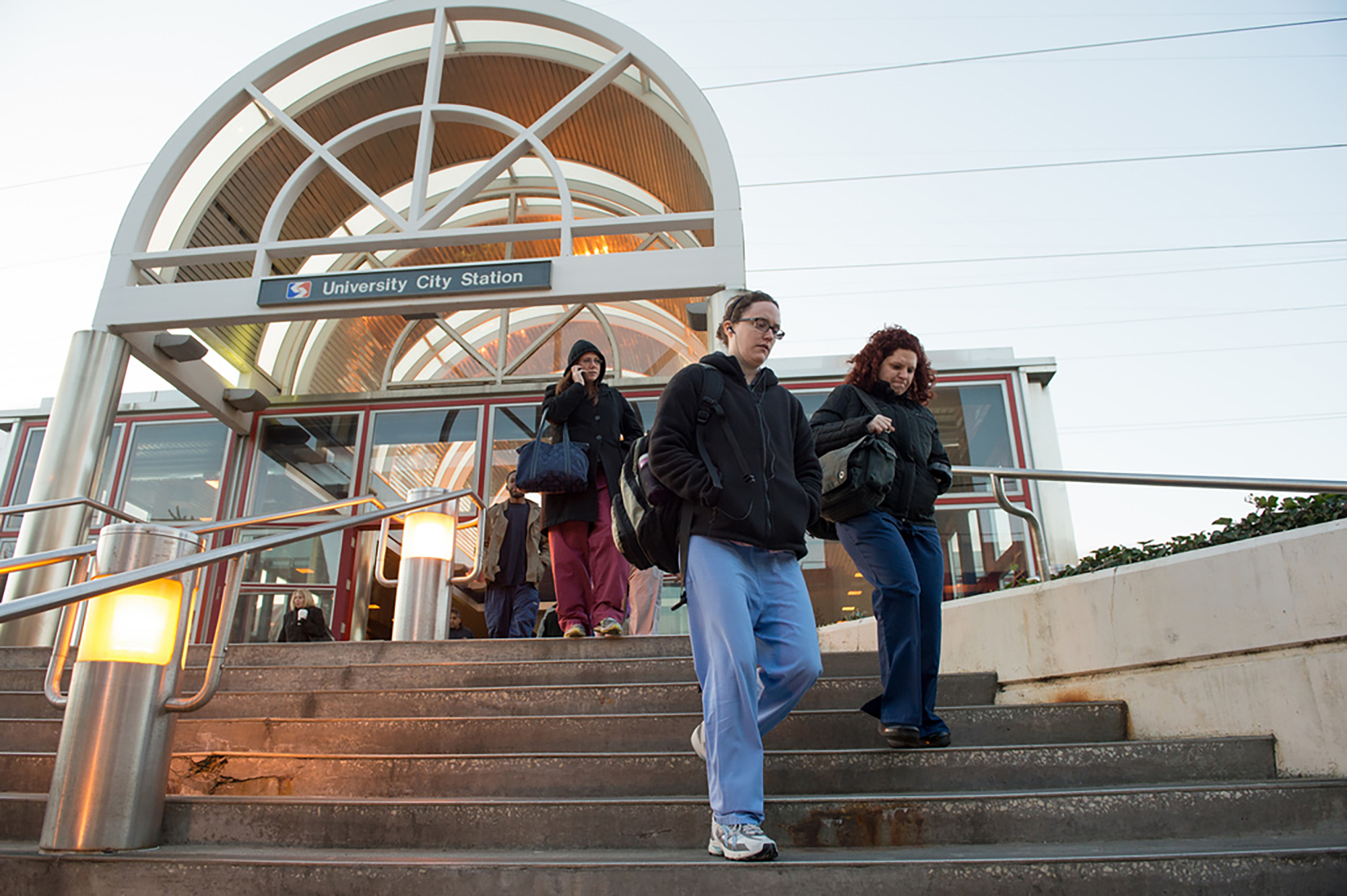 Commuters exiting Septa's University City Station outside walking down the stairs.