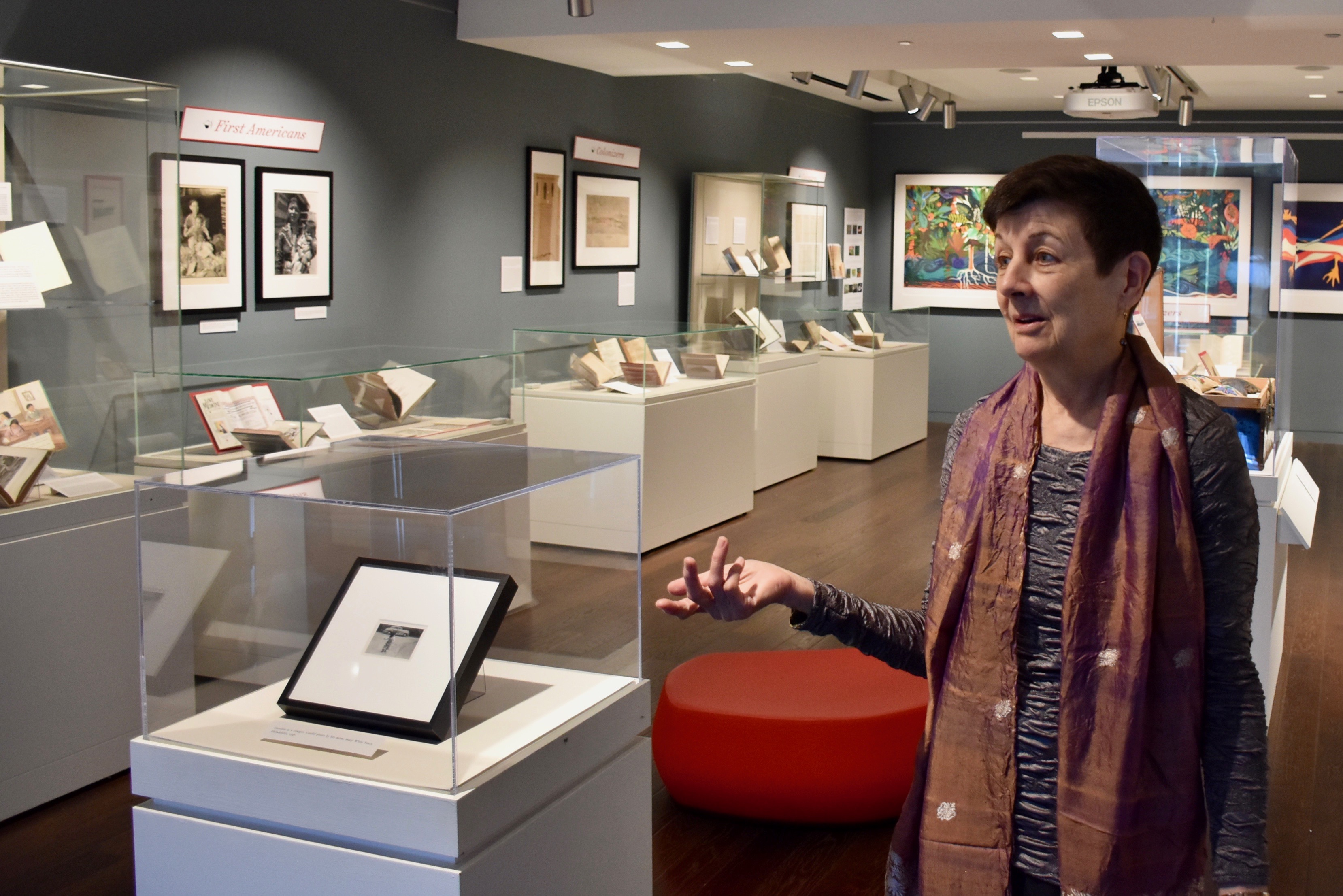 Penn-alumna-Caroline-Schimmel-standing-in-Penn-Libraries-gallery-with-her-collection-of-women-in-the-American-wildnerness