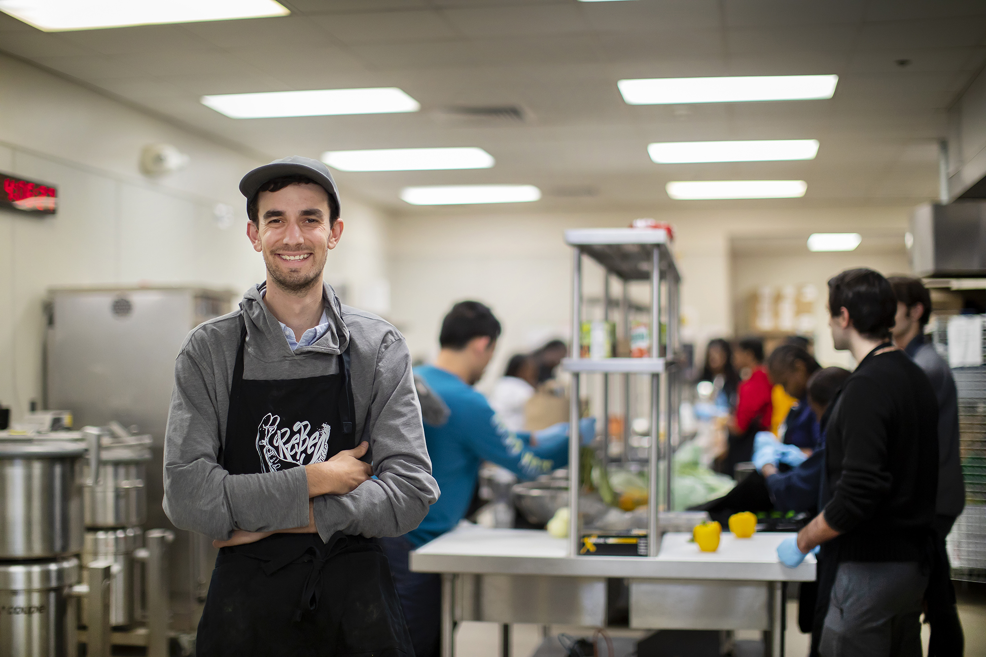 Jarrett Stein stands in front of busy workers in a large kitchen