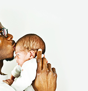 father-kissing-newborn-son-on-forehead