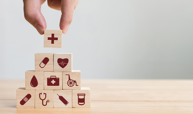 building blocks with prints of pills stethoscope and needle