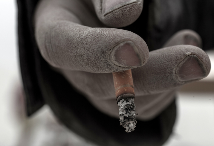 closeup of frozen hand holding lit cigarette