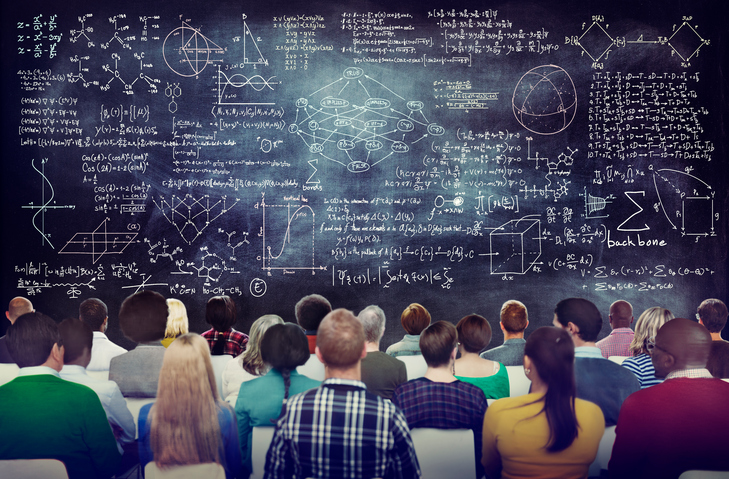 students-facing-a-blackboard-covered-in-complex-math-equations