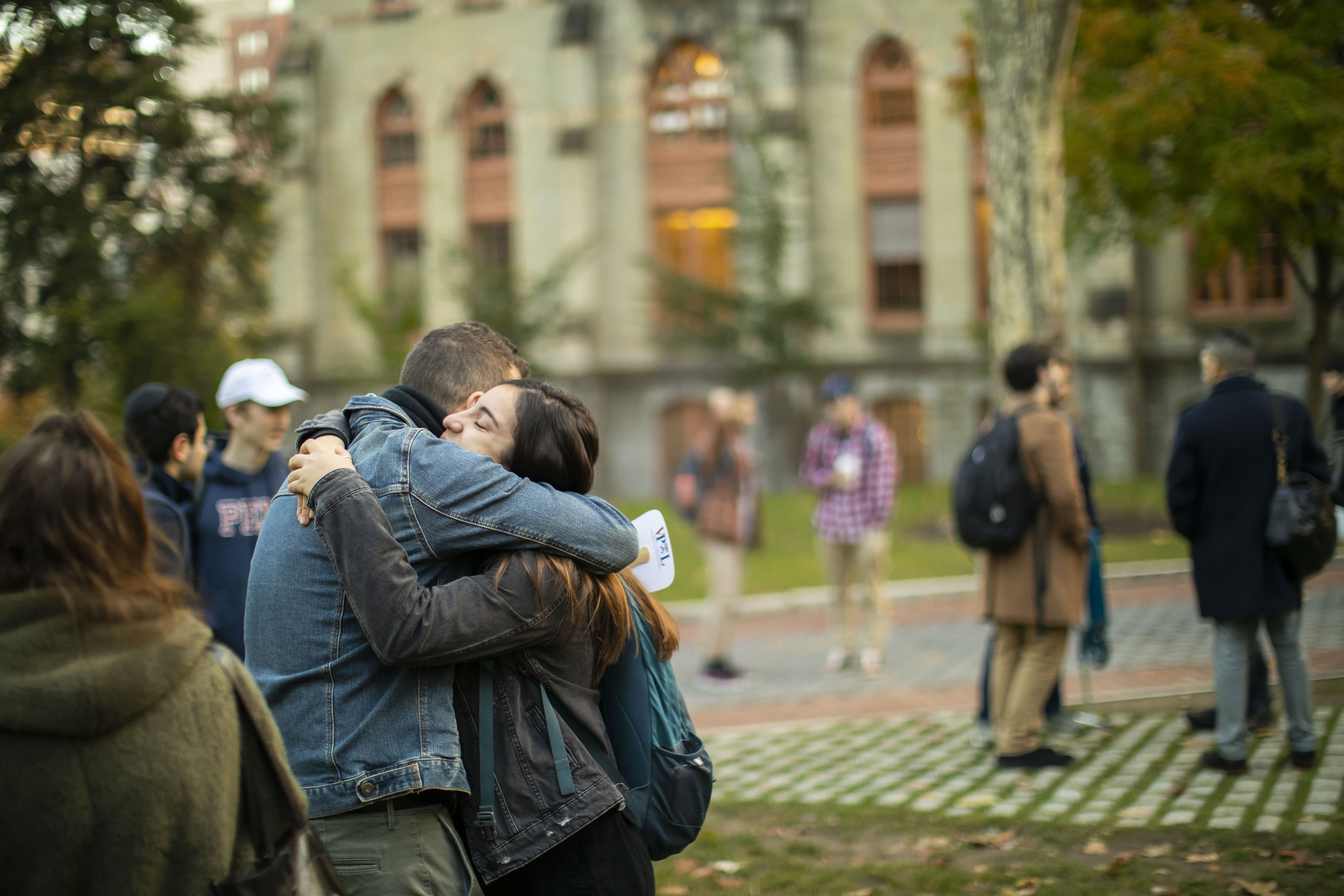 two people embrace in front of College Hall