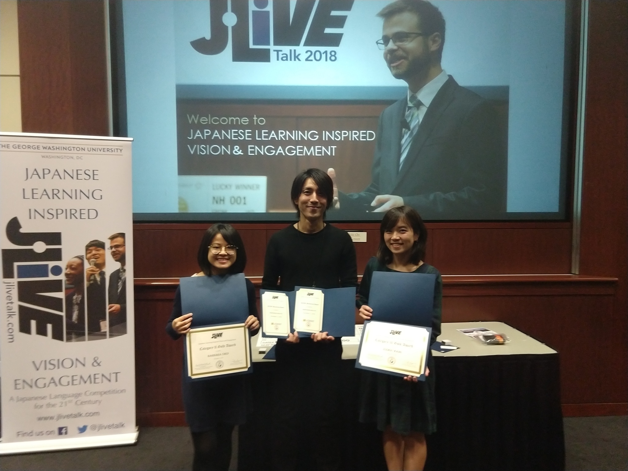 Barbara, Kinji, and Zizhou holding awards from the language competition