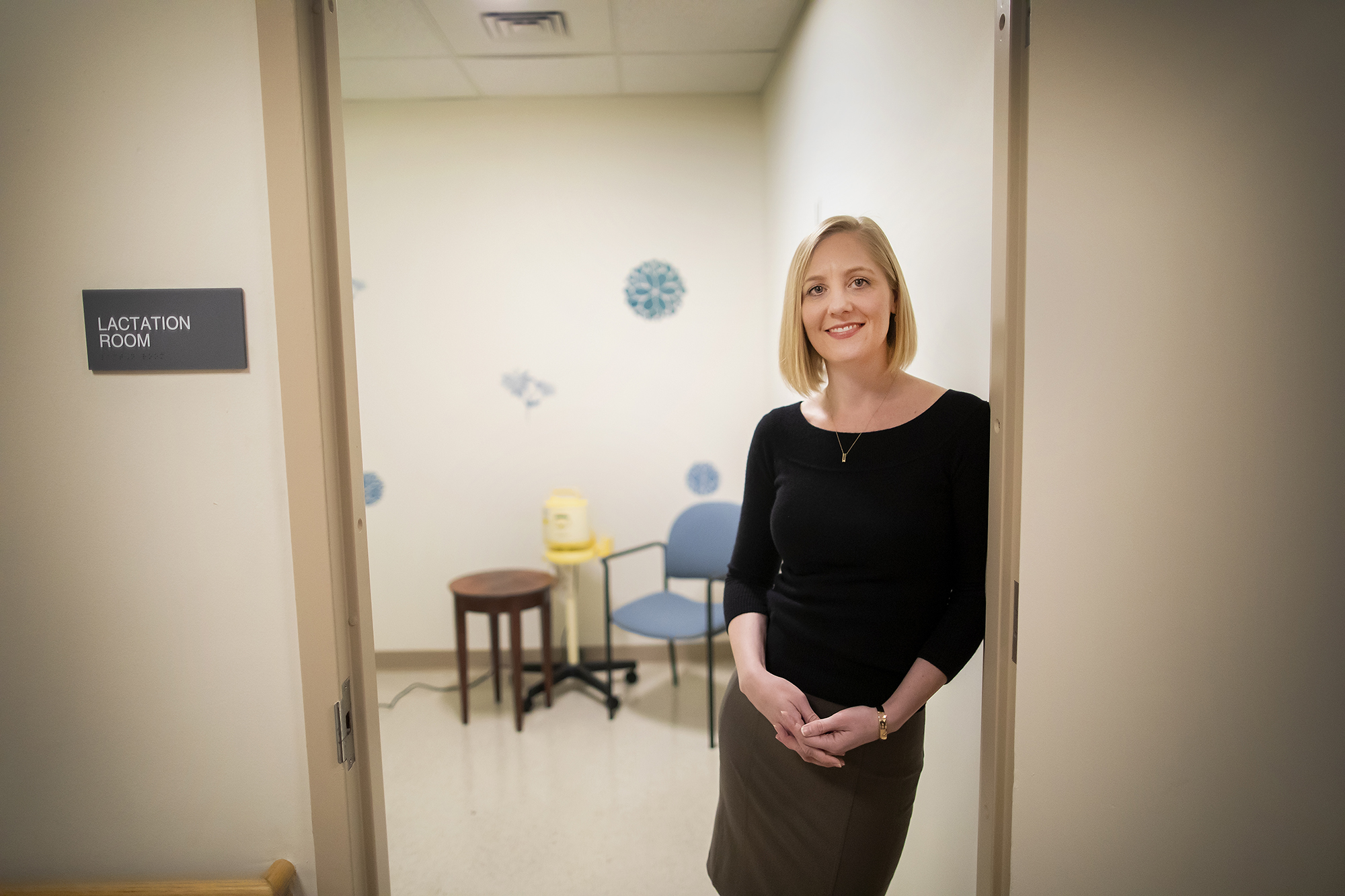 Dare Henry-Moss leaning against the doorway of a new lactation room, with a breast pump in the background