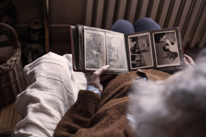 old photo album in the lap of an elderly person