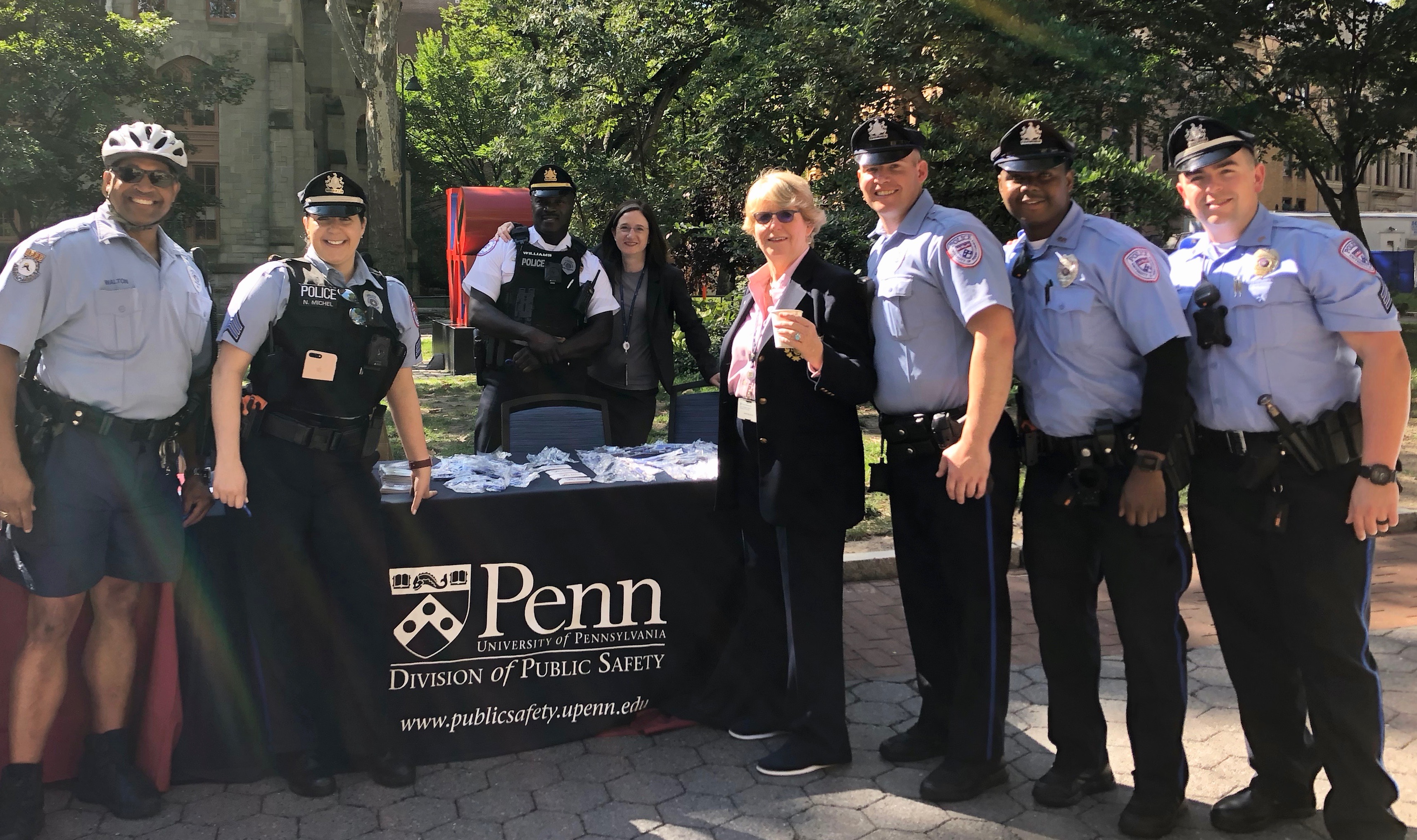 Uniformed police officers pose in front of a table on Locust Walk