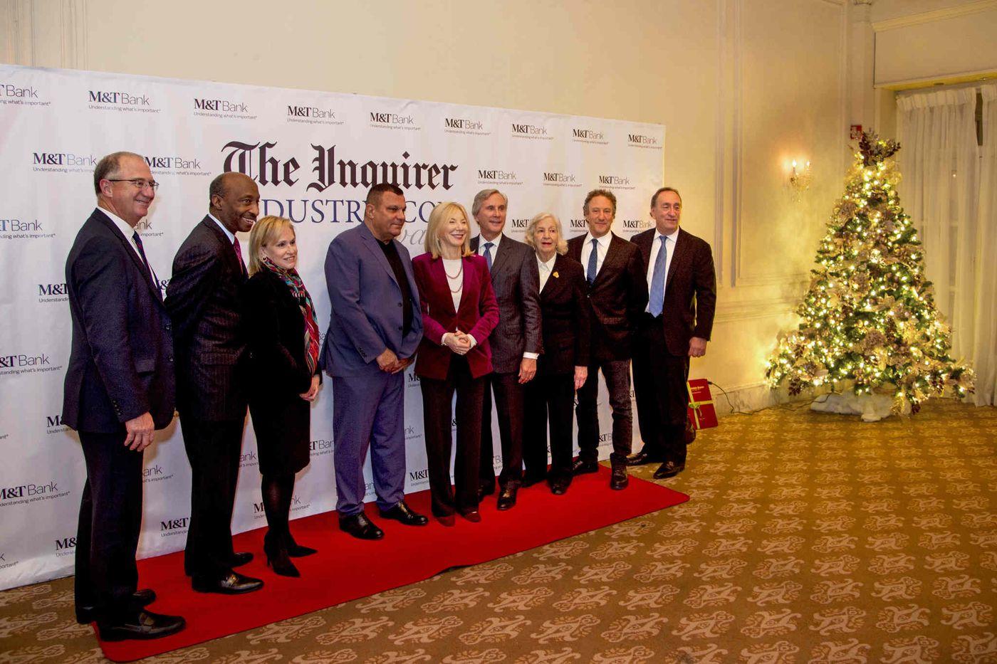 Recipients lined up in front of a photo backdrop