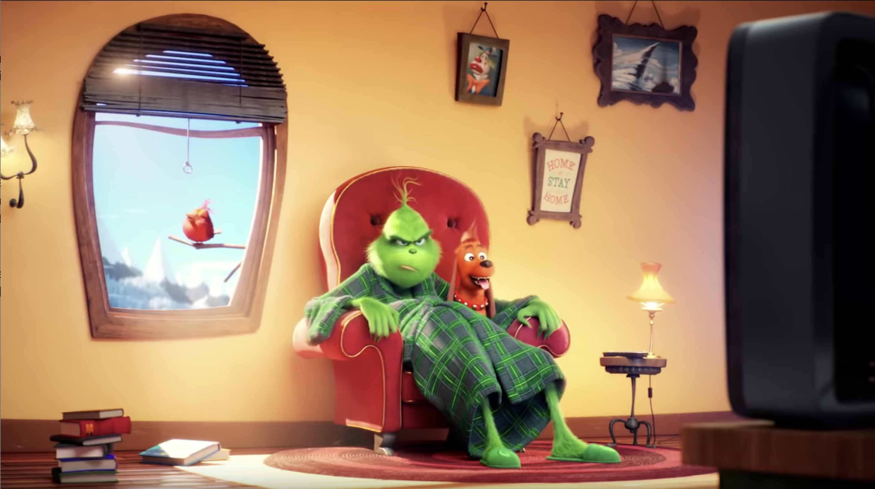 The Grinch lounges on a chair looking grouchy