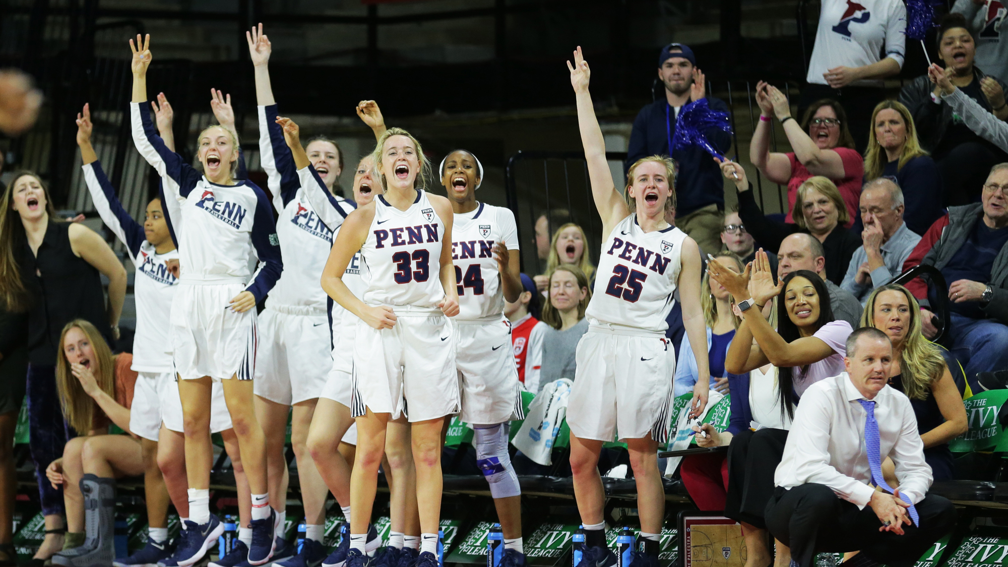 Players on the women's basketball team cheer on their teammates from the bench at The Palestra