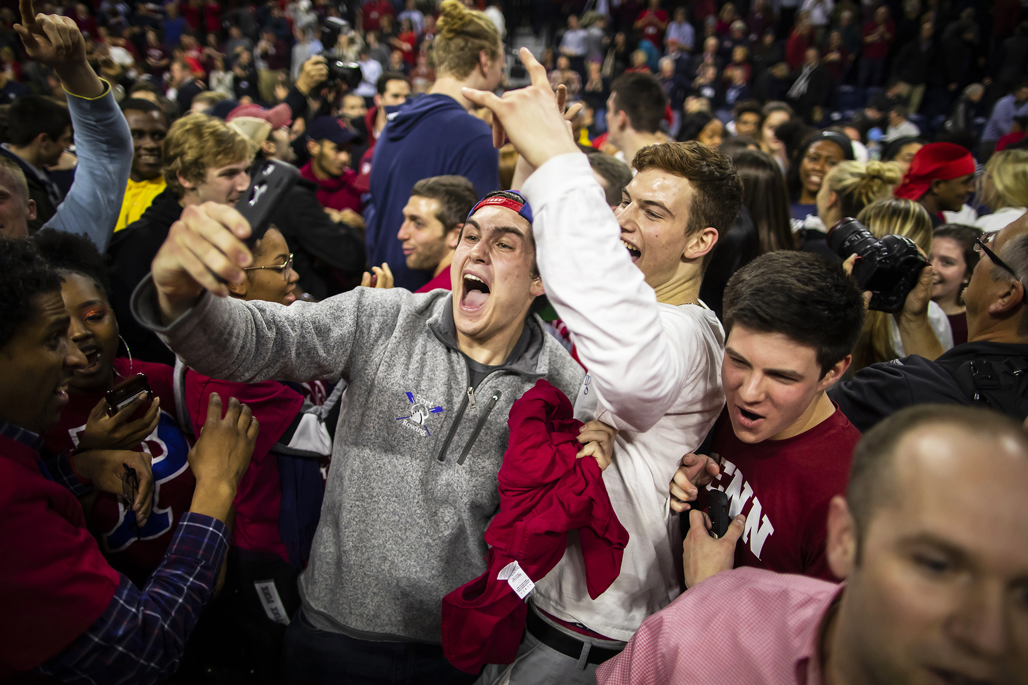 Penn basketball fans celebrate on the court after beating Villanova