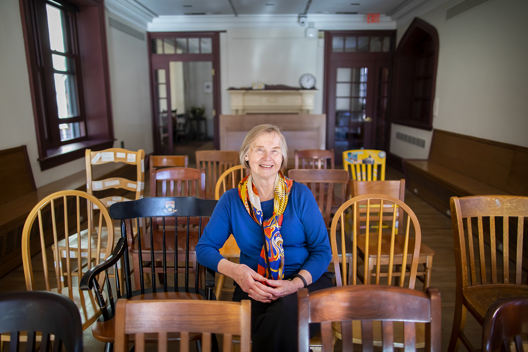 Deborah Burnham sits in Kelly Writers House, surrounded by wooden chairs
