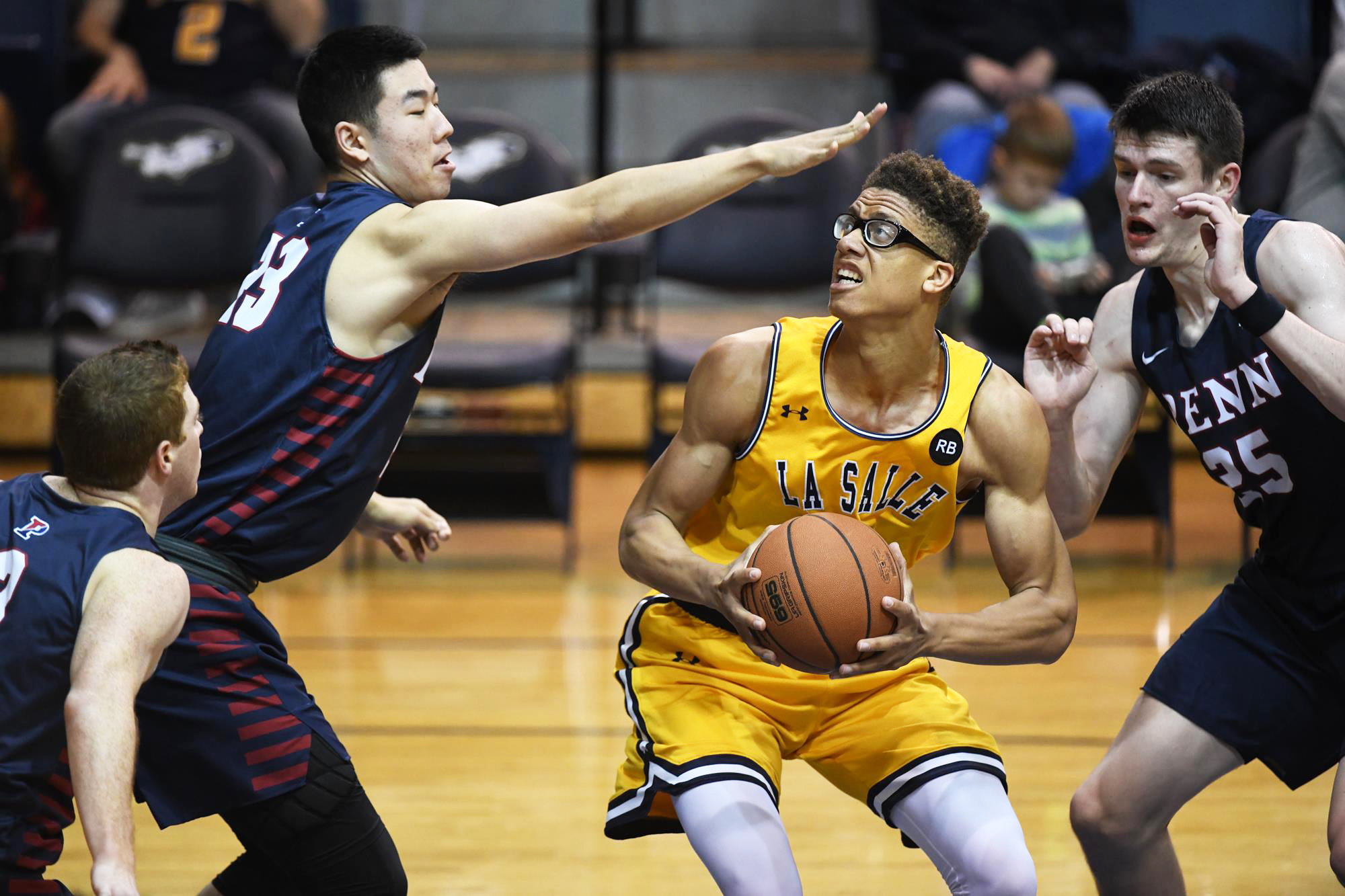 Three Penn basketball players play defense against a La Salle player with the ball