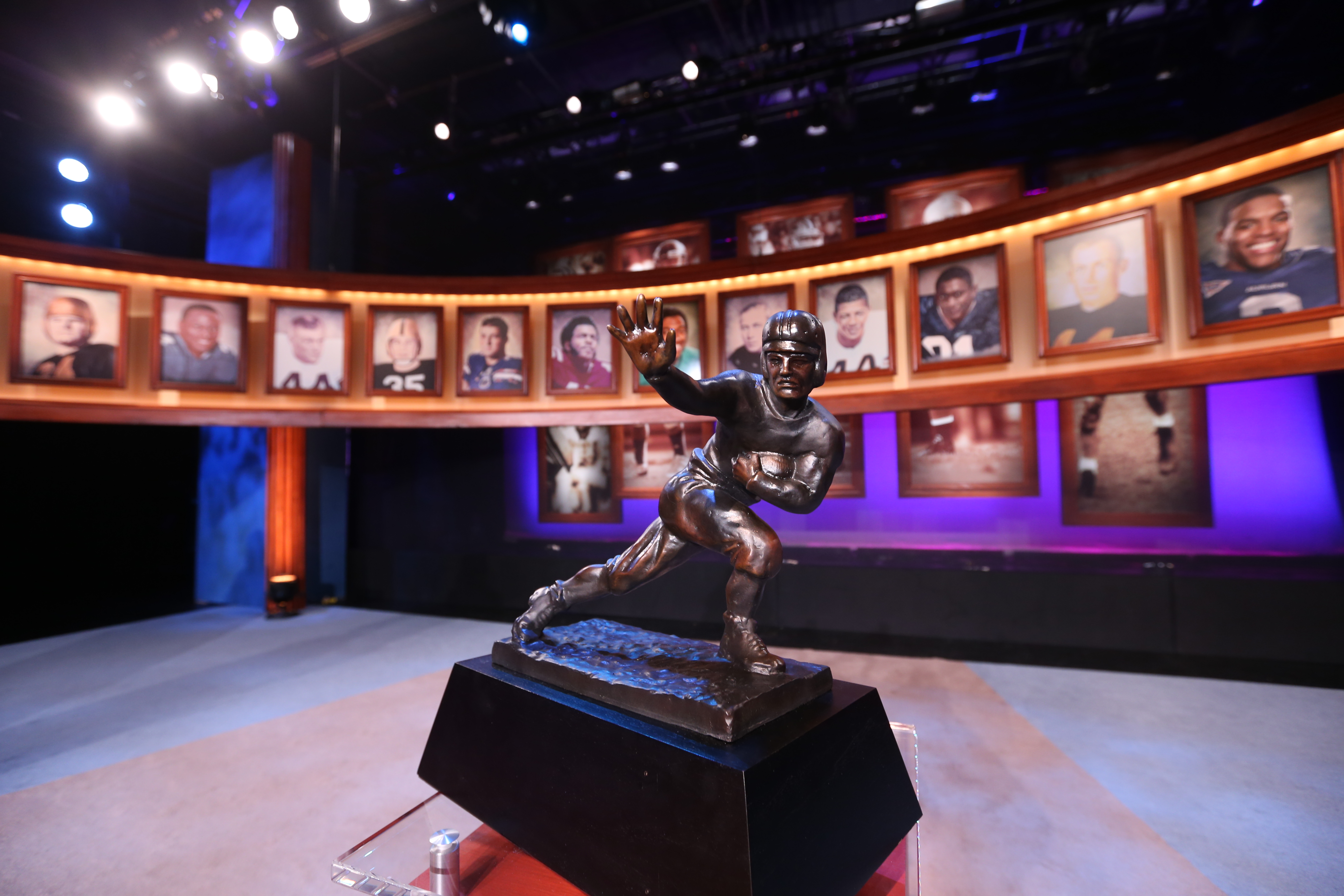 The Heisman Trophy surrounded by photos of past winners