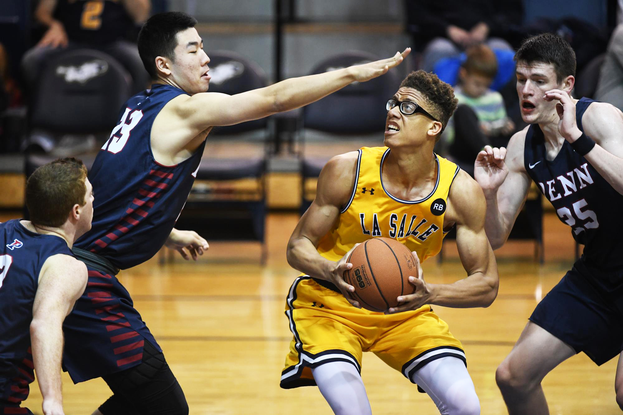 Penn players defend La Salle player with the ball at Tom Gola Arena.