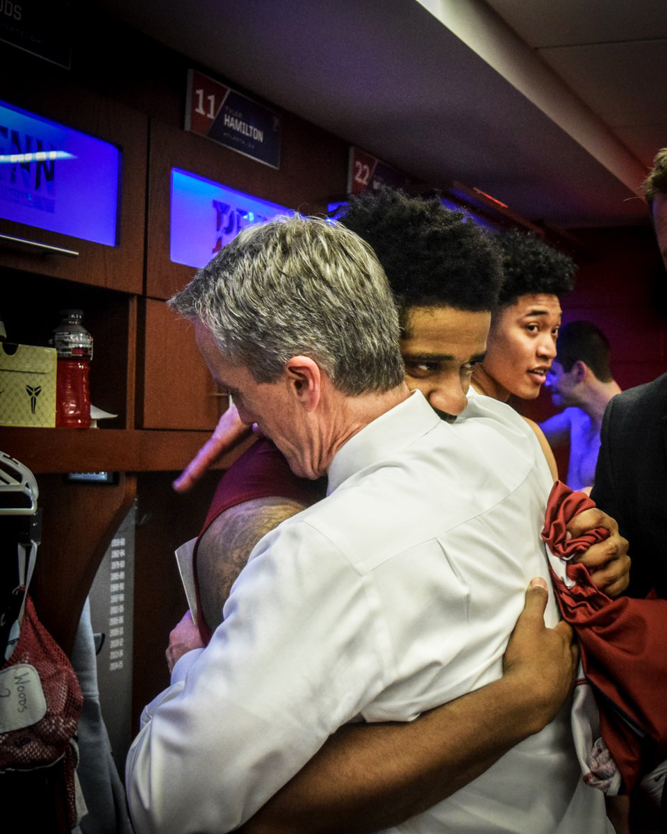 Head Coach Steve Donahue and senior guard Antonio Woods embrace in the locker room after defeating Saint Jospeh's.