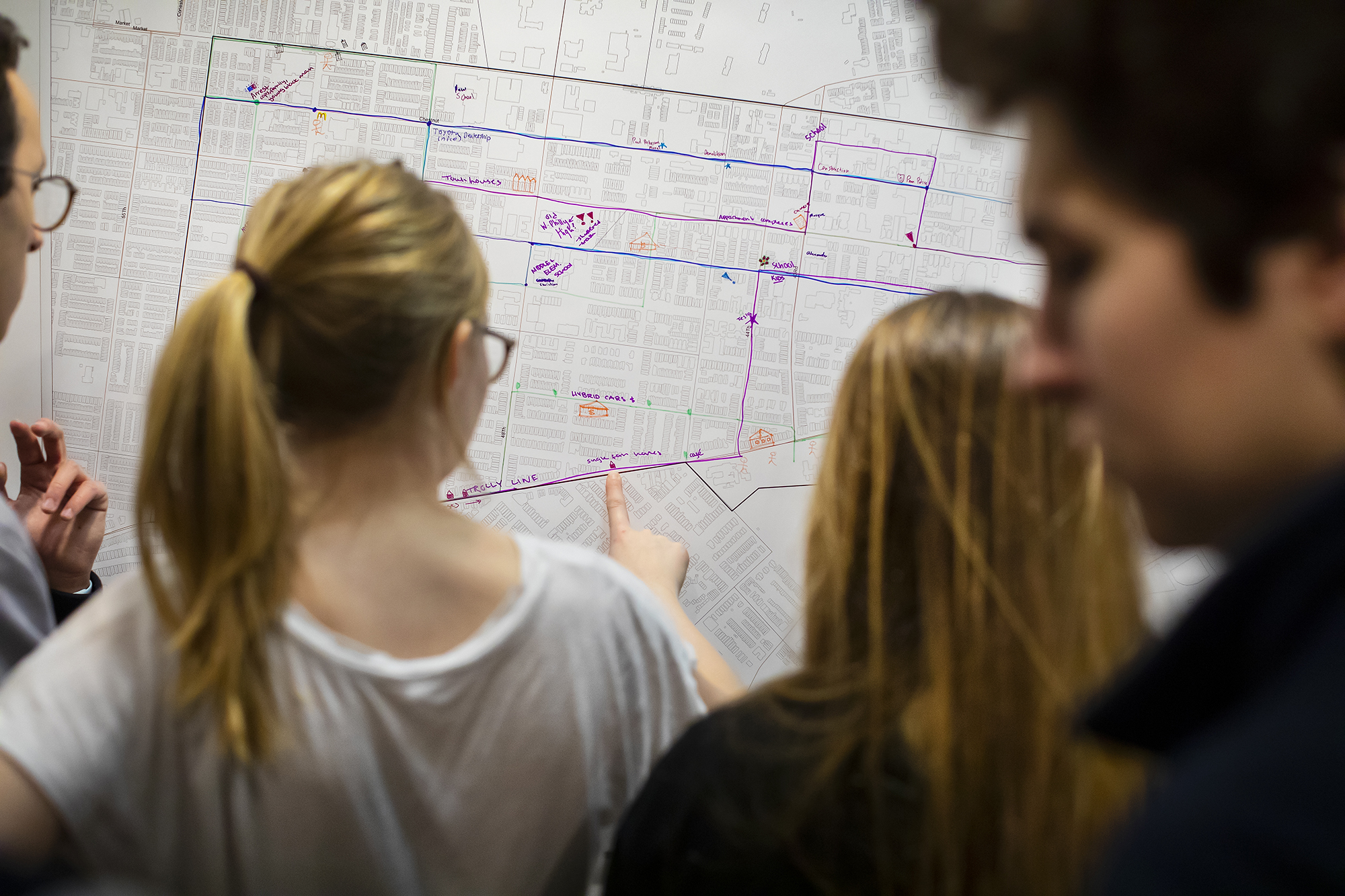 Students working on a map on a wall. 