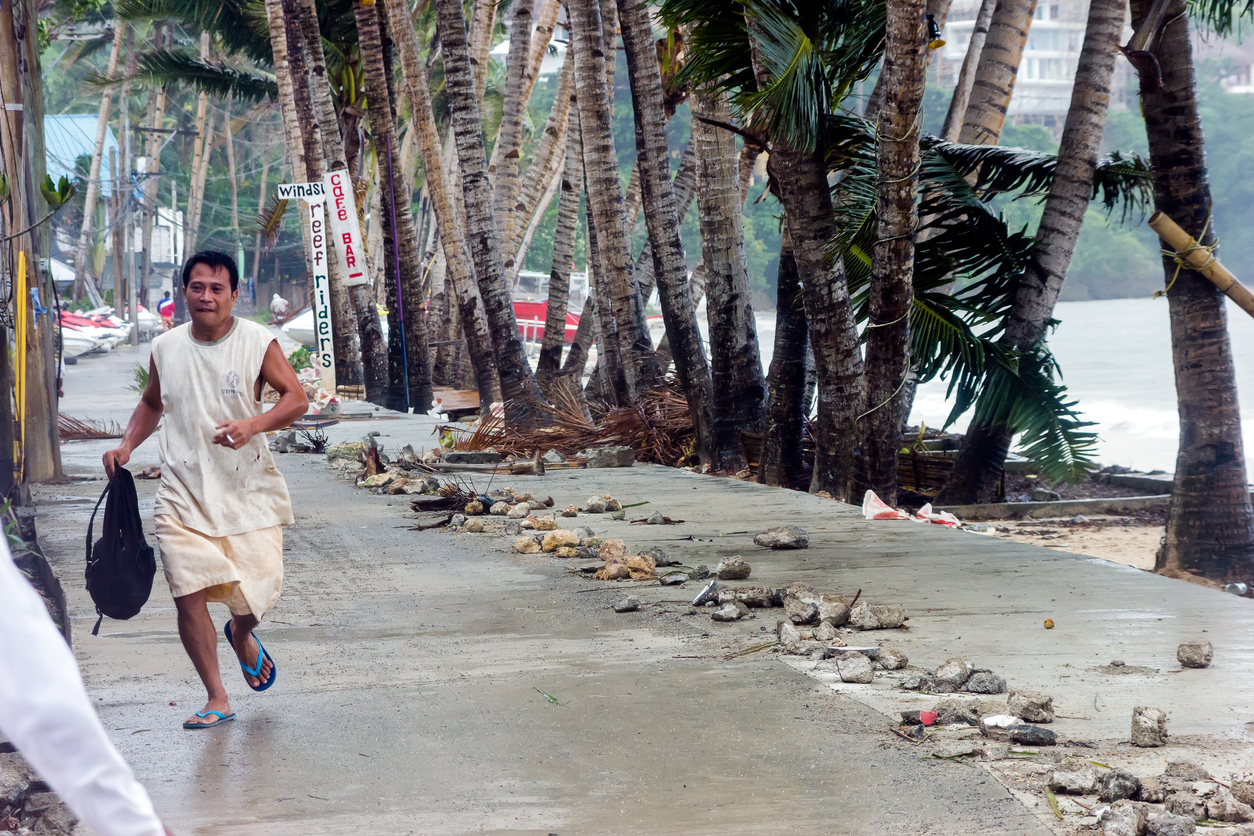 Man running during Super Typhoon storm in Philippines