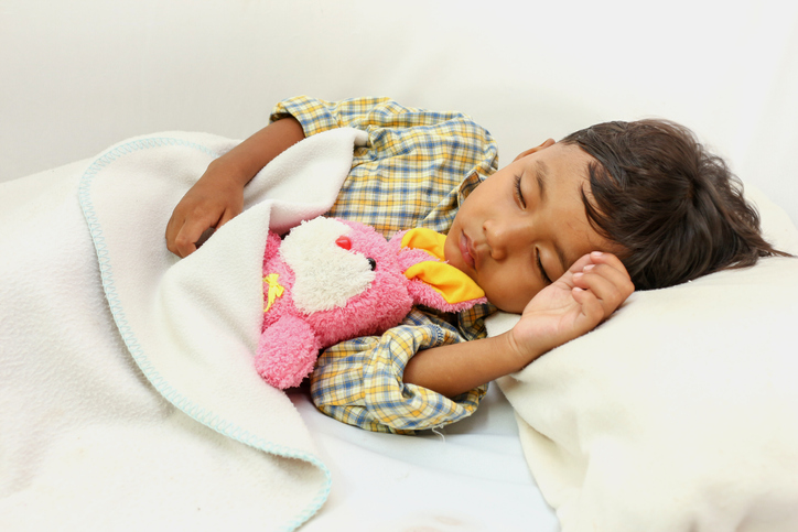 toddler asleep in bed with stuffed bunny toy