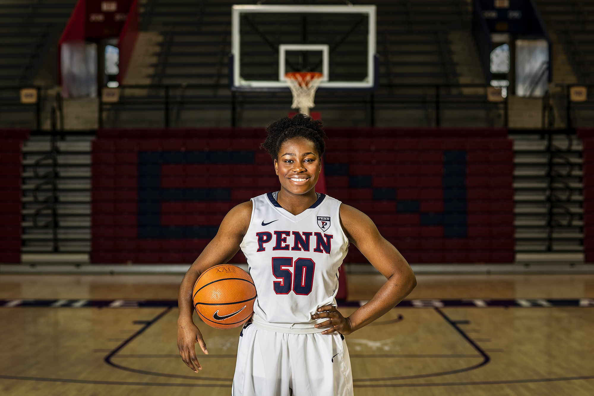 Princess Aghayere poses with a basketball on center court at the Palestra.