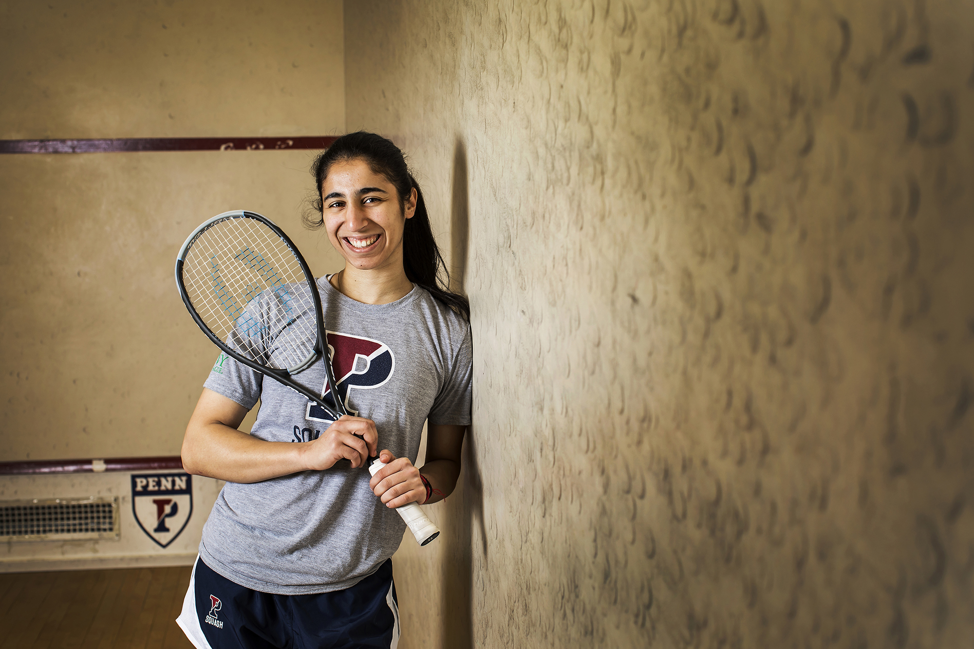 Reeham Sedky poses with her squash racket on the squash court.