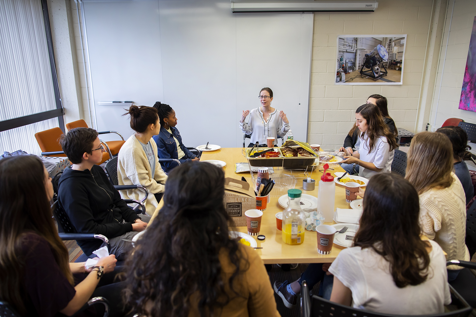 a group of women talking while sitting around a table