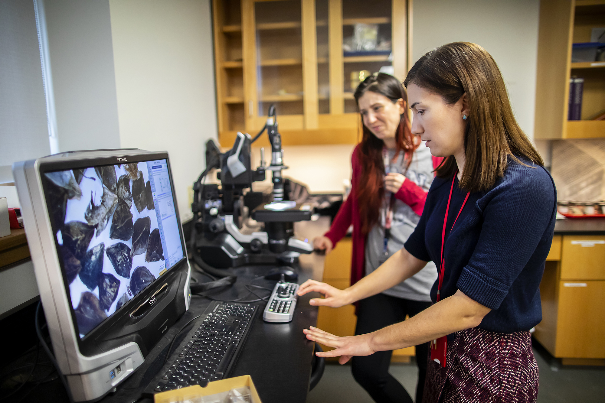 researching looking through microscope at penn museum caam