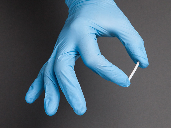 gloved hand holding naltrexone implant
