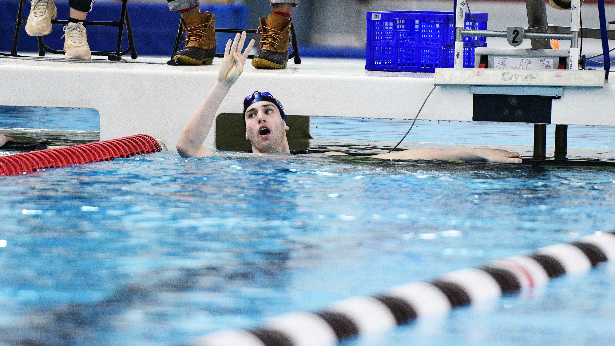 Mark Andrew holds up four fingers after winning four straight 200 IM at Ivy Championships.