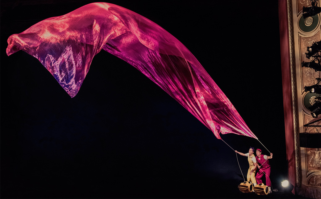 Tapestry held by two people blows in the air