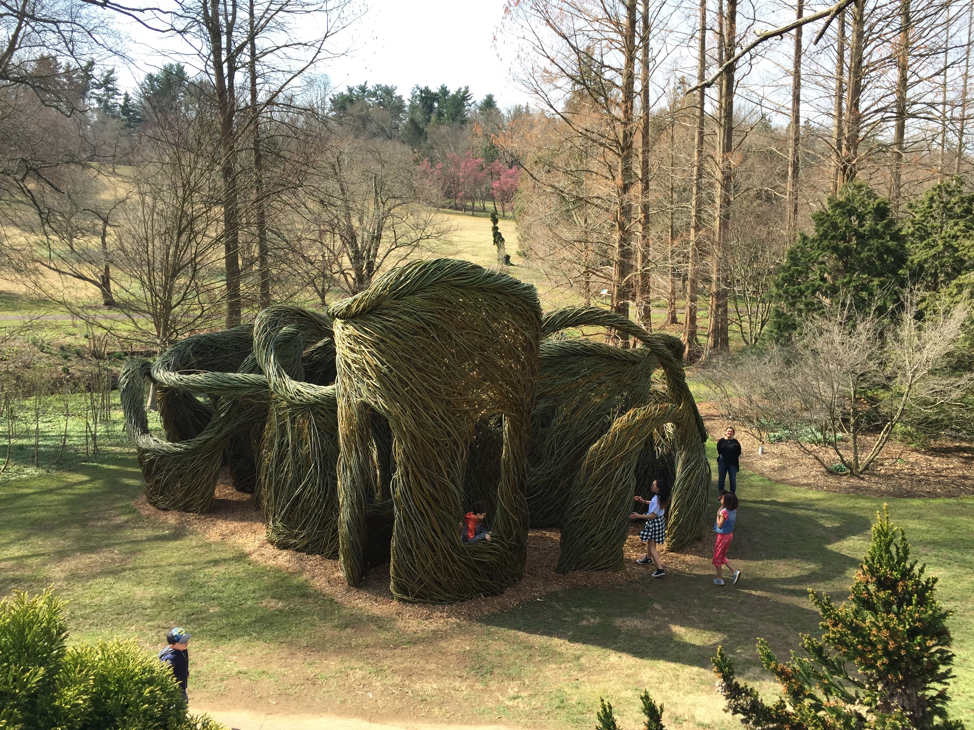 Sculptural towers made of sticks with trees in background