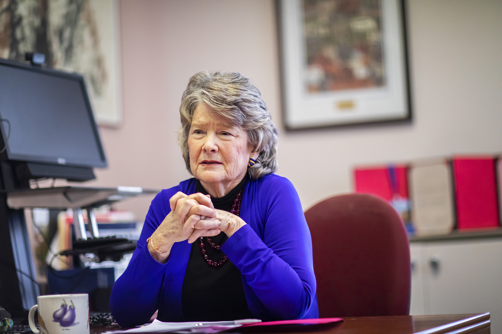 Leslie Laird Kruhly sitting in office chair with mug