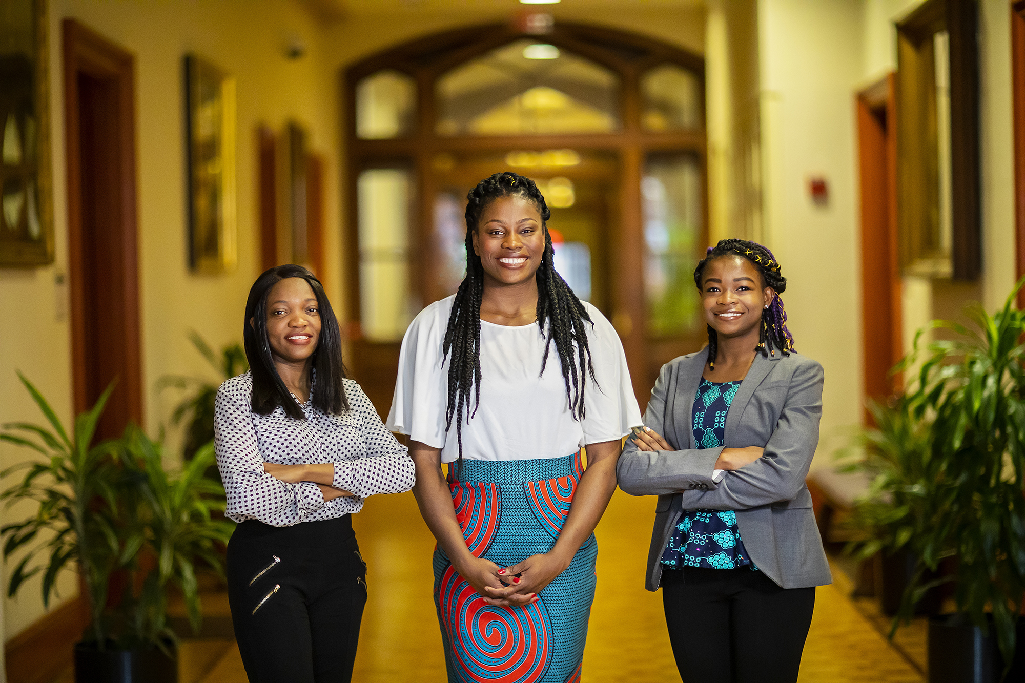 Three women standing in a hallway