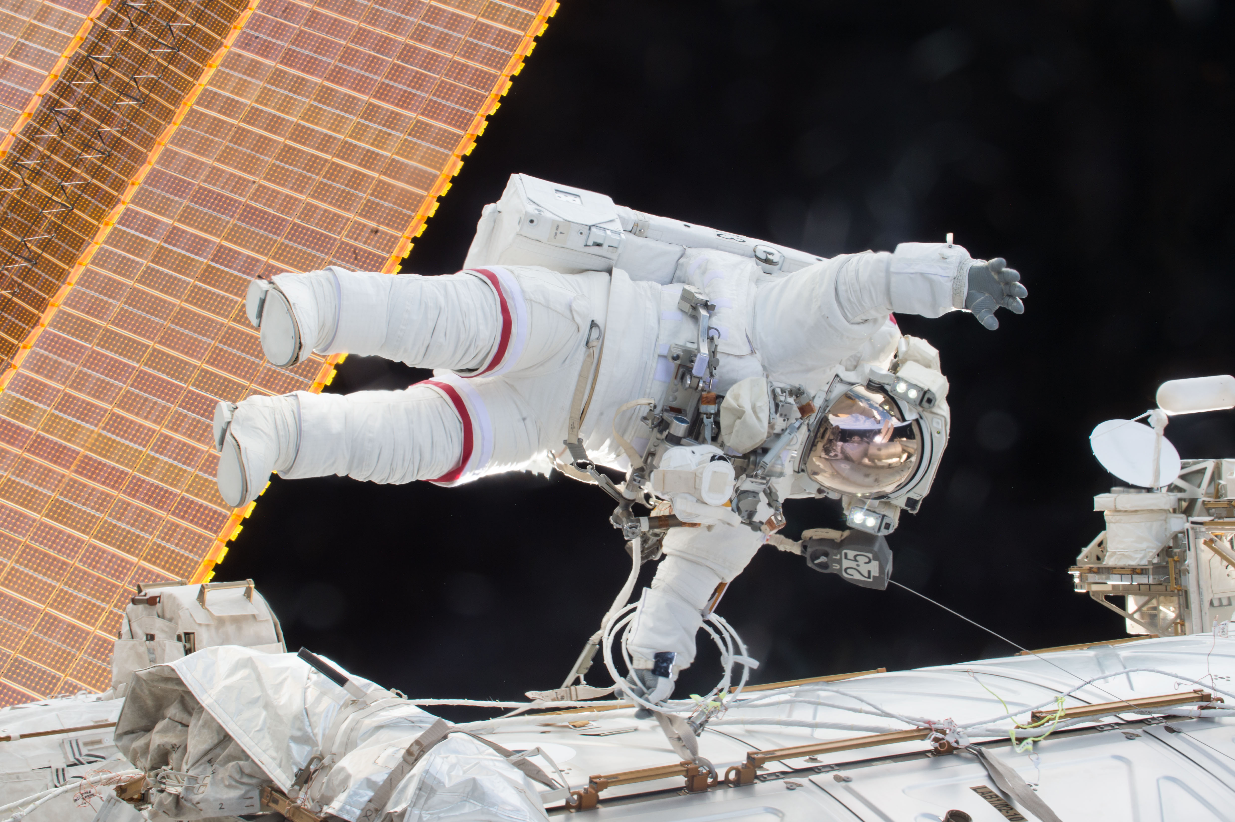 Astronaut in a space suit on a spacewalk outside the International Space Station. 