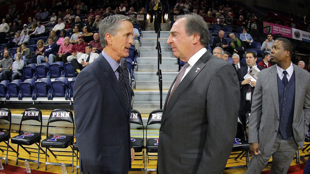 Penn head coach Steve Donahue speaks with Temple head coach Fran Dunphy on the sidelines.