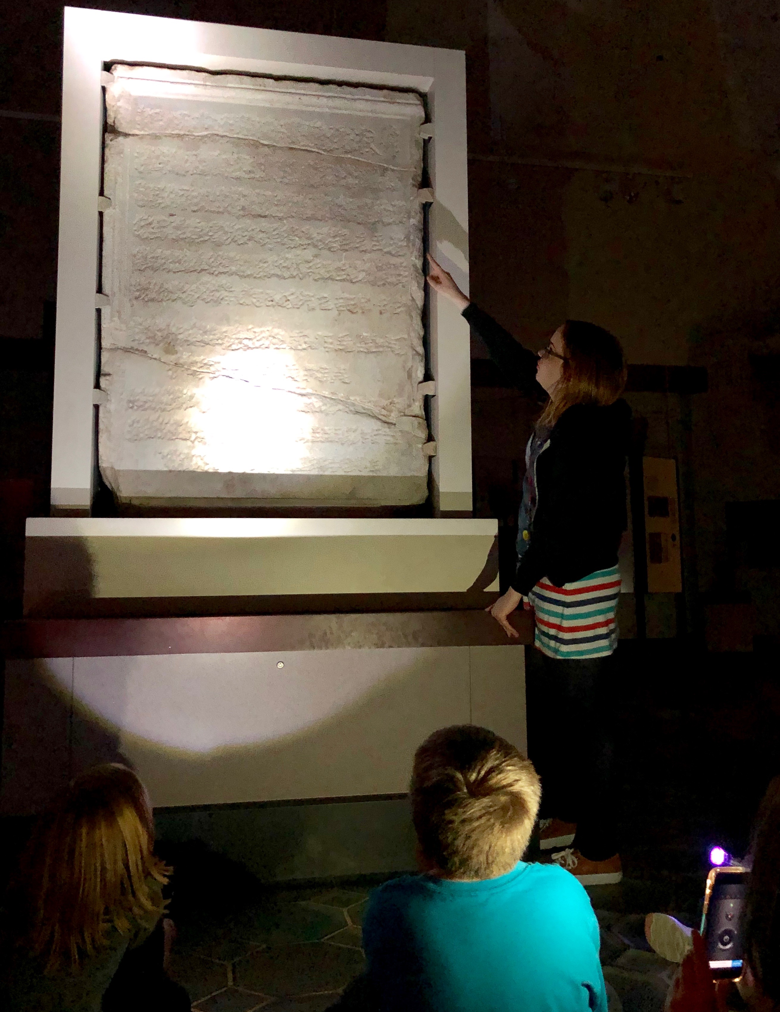 Megan Becker showing children a marble tablet