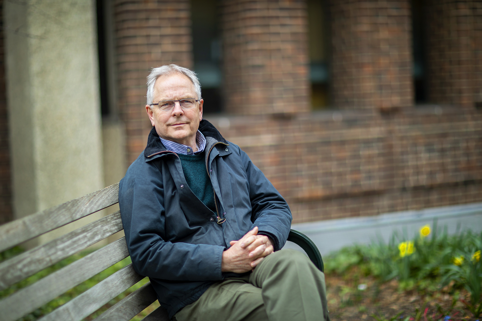 James Serpell on a bench with hands crossed