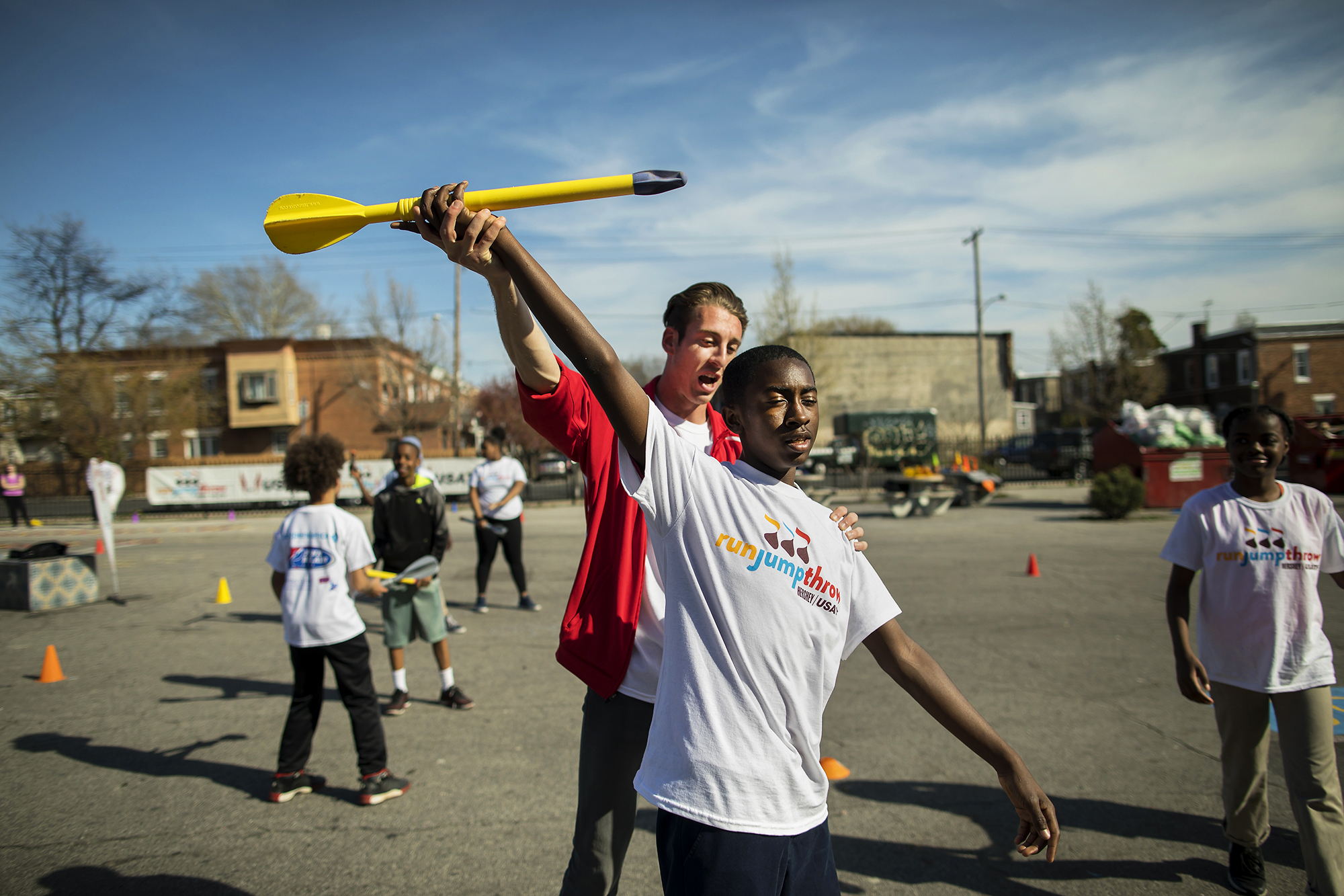 Jeff Wiseman, a middle-distance runner on the Penn track & field team, instructs seventh-grader Sufyaan Russell in the javelin throw. 