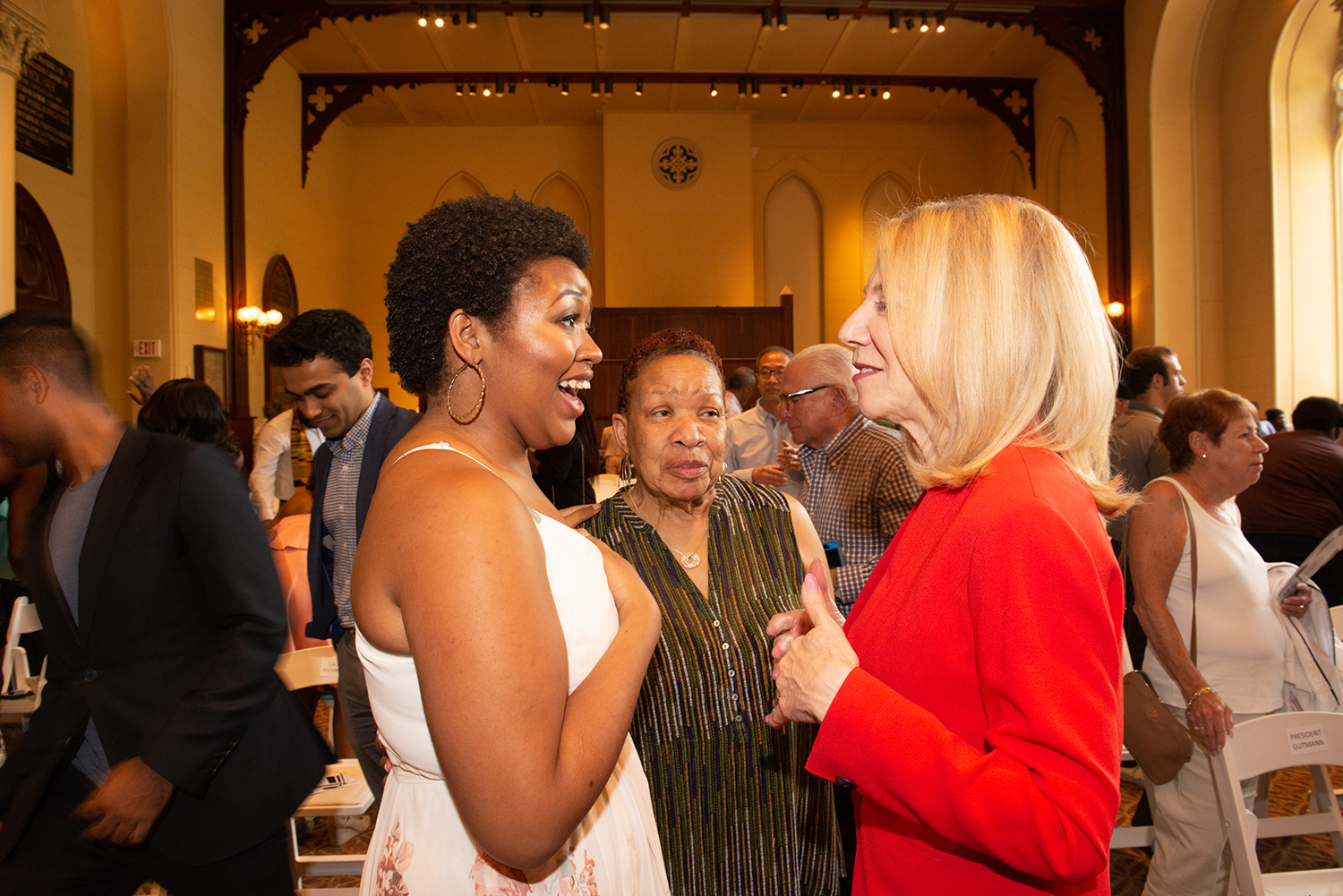 Anea Moore faces Amy Gutmann in conversation while standing