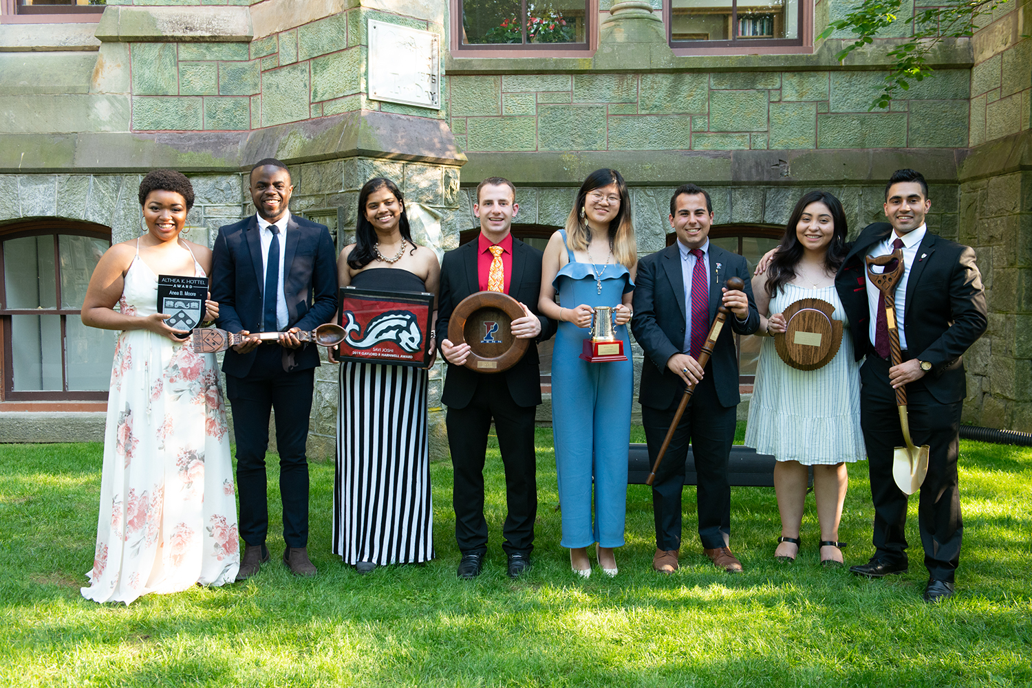 Anea Moore, Calvary Rogers, Savi Joshi, Ryan Leone, Julia Pan, Michael B. Krone, Candida Alfaro, and Aren Raisinghani stand outside in front of College Hall holding awards.