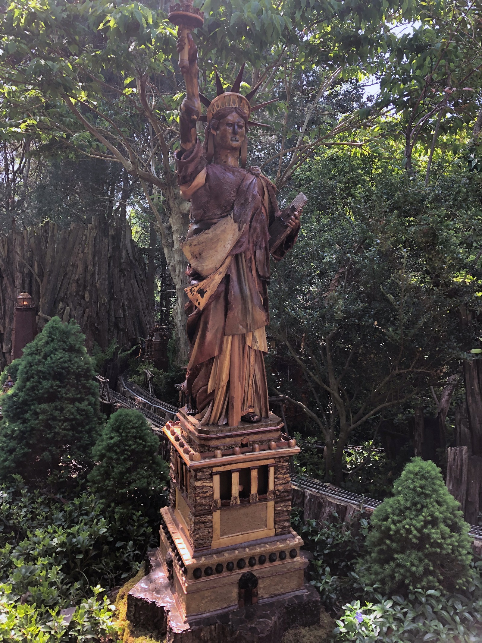Statue of Liberty made with natural materials surrounded by shrubs