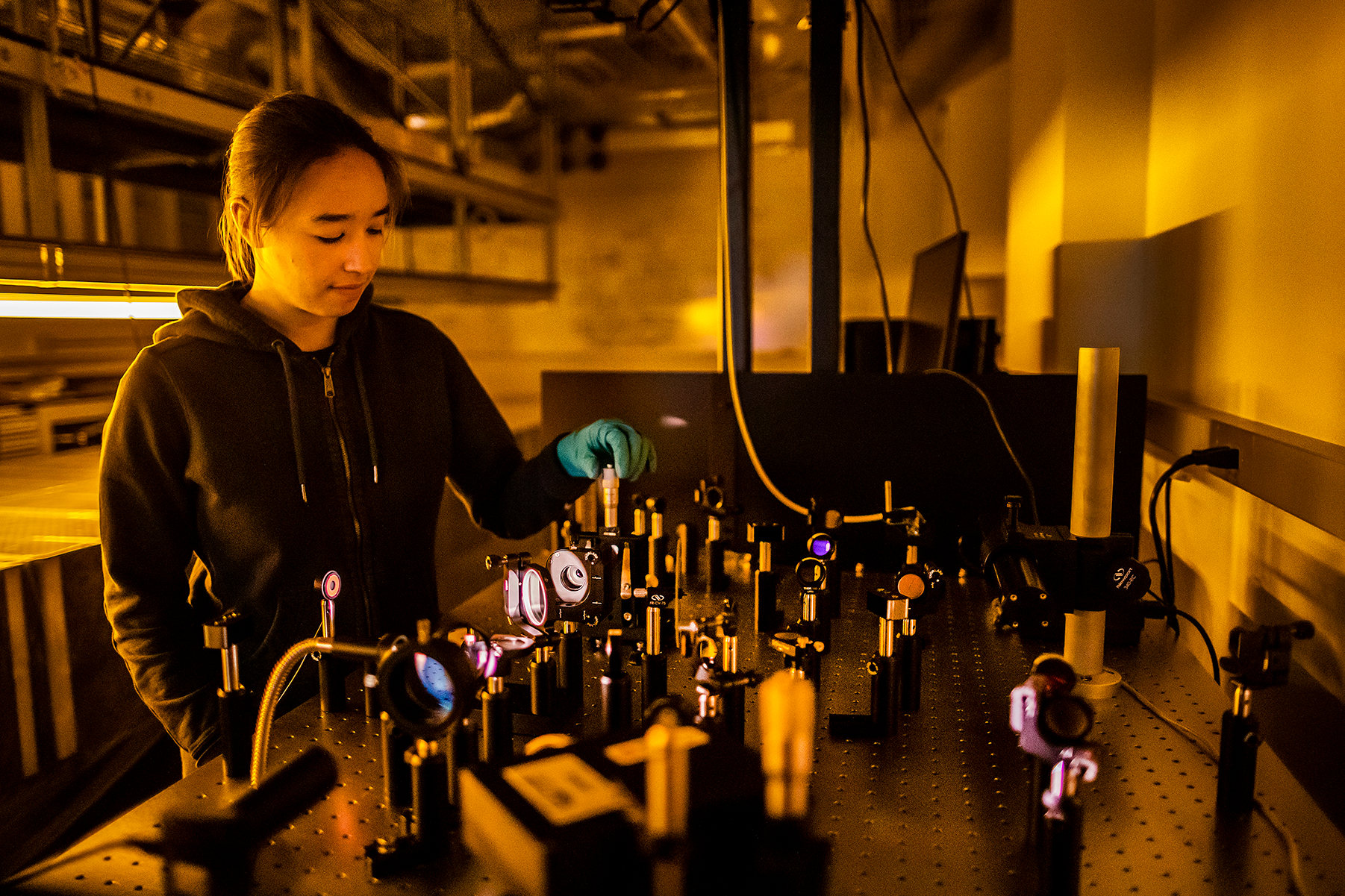 a person adjusting a lens on an optics table