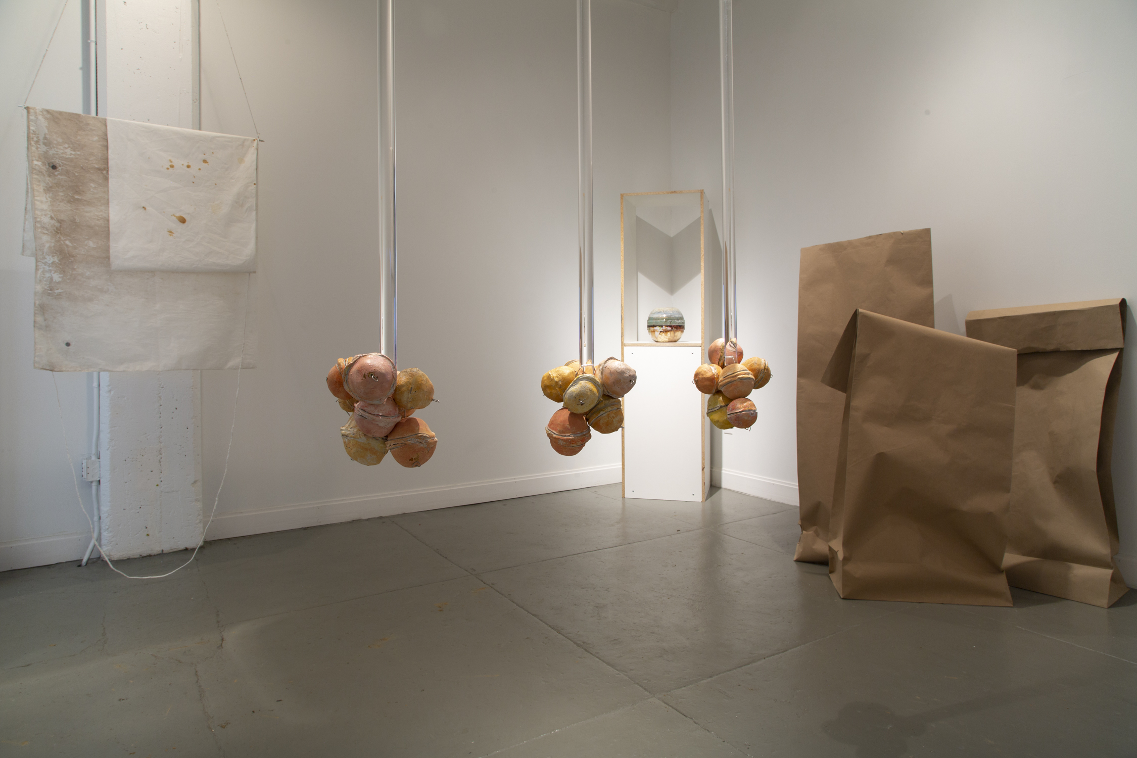 Balls hang from ceiling with paper bags in the background