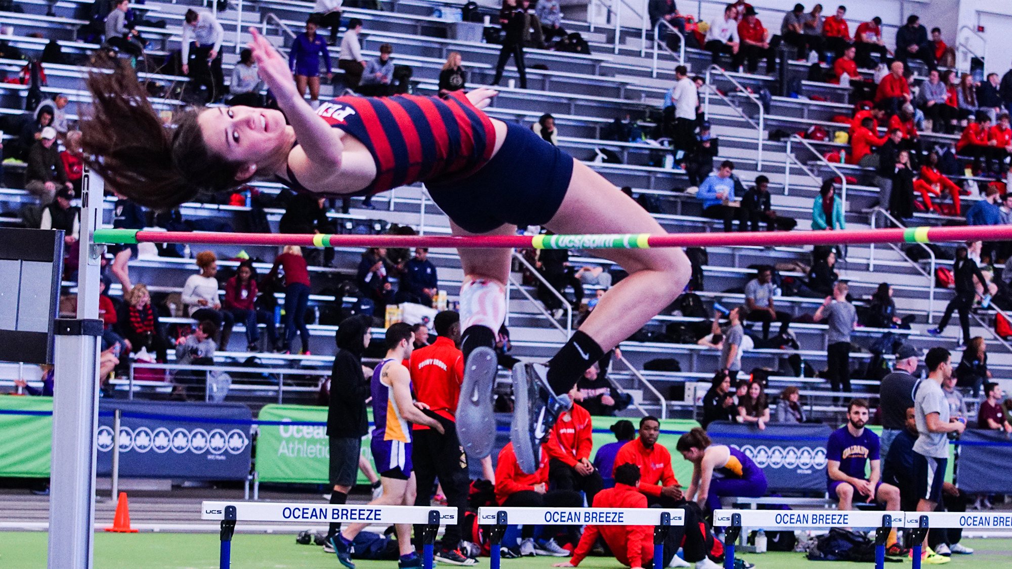 Anna Peyton Malizia jumps over the high jump bar at an outdoor meet.