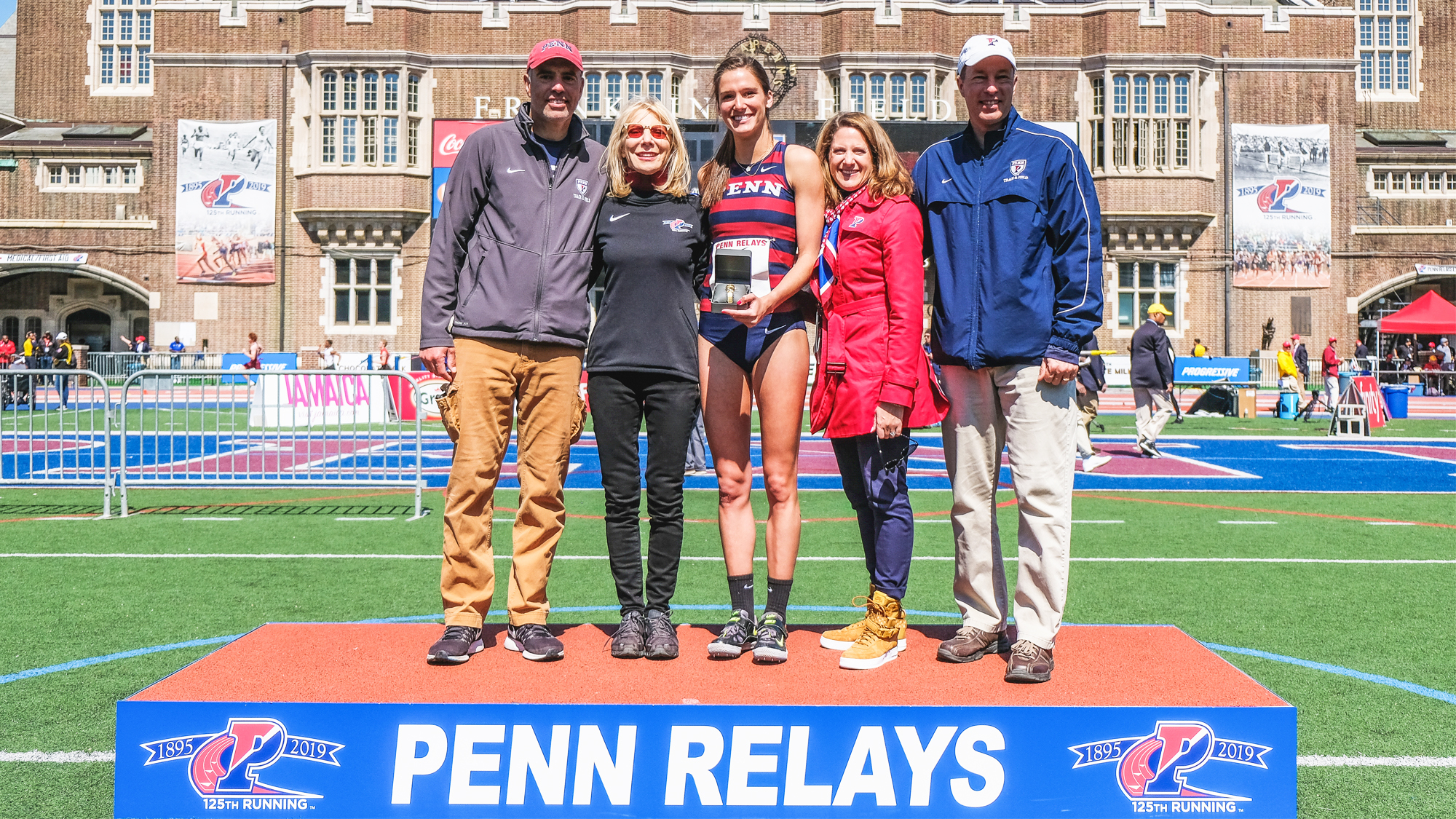 Anna Peyton Malizia poses with Dr. Amy Gutmann and AD Calhoun at the Penn Relays.