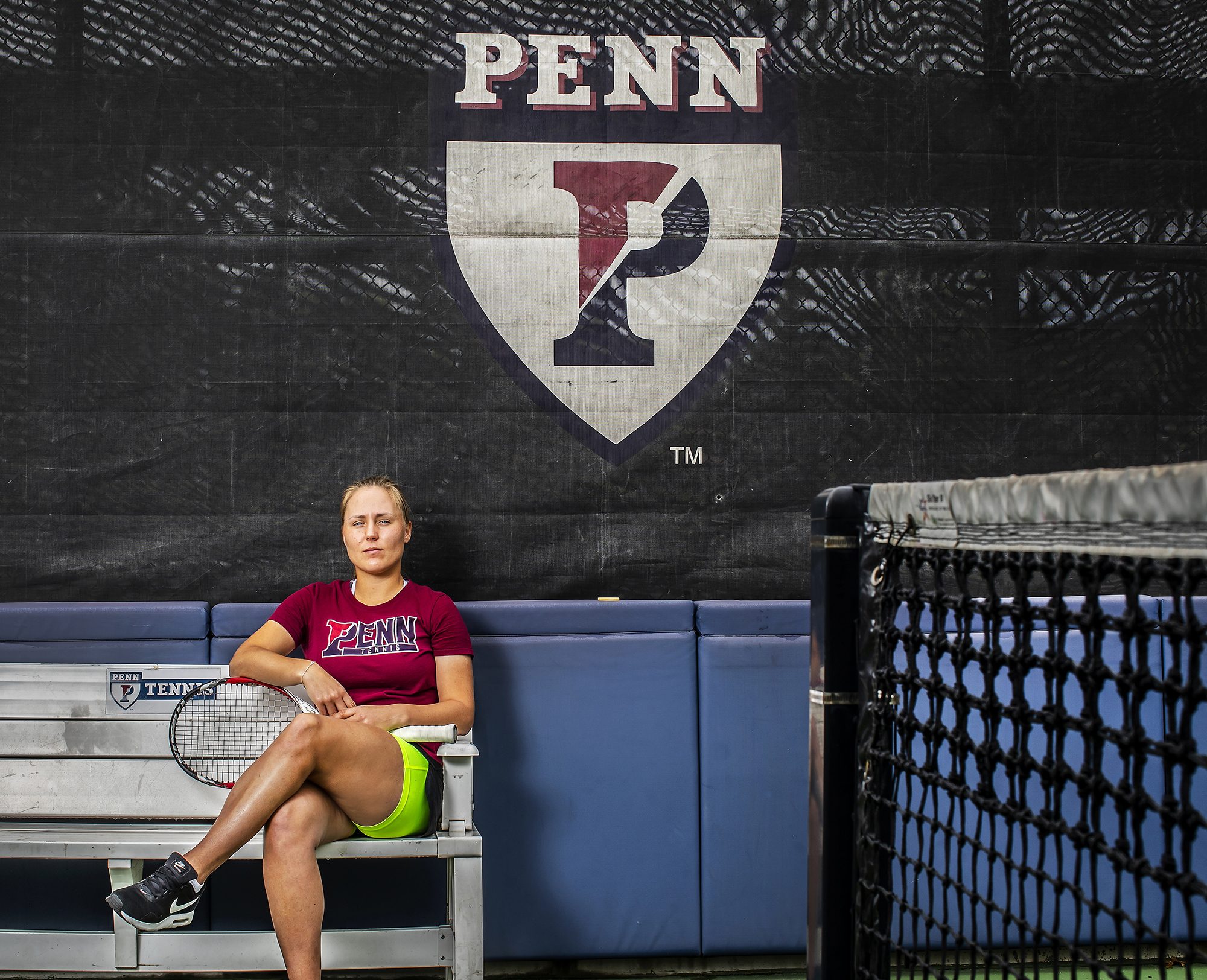 Iuliia Bryzgalova poses on a bench with her racket at the tennis courts at Penn Park.
